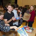 Studio C cast members Whitney Call (left) and Matt Meese (center) visit build personal hygiene kits with youth from The Church of Jesus Christ of Latter-day Saints in Redmond. Courtesy of Buckland Darrell