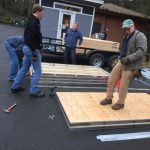 Off-duty firefighters and Michael Grimm of Camp Unity Eastside (center) work together last weekend to build steel platforms to go underneath tents in the encampment. Courtesy photo
