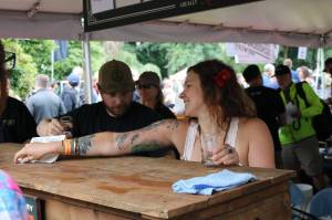 Karen Troy, taproom manager for Black Raven Brewing in Redmond, staffs the kiosk during last weekend&rsquo;s Washington Brewers Festival at Marymoor Park. Aaron Kunkler/Redmond Reporter