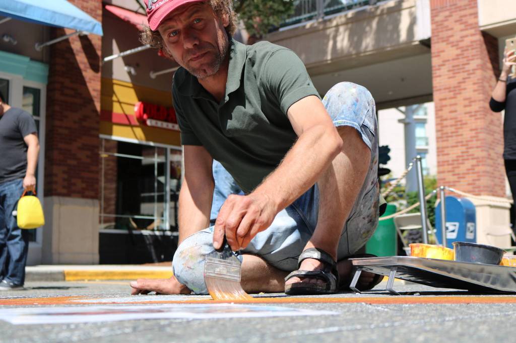 Netherlands-based artist Remko Van Schaik uses paint to create his art last Saturday at the Chalk Fest. Aaron Kunkler/Redmond Reporter