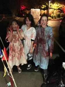 From left to right, Redmond High volunteer Elaina Barbosa, professional actor Mary (last name withheld) and Redmond High volunteer Anna Hill get their screams on at last Saturday&rsquo;s Redmond Ridge Trail of Terror. Courtesy of Chanel Merritt