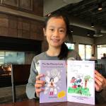 Amy Zhao shows off two of her books. The 9-year-old has published four books following her fairy characters. Samantha Pak, Bothell/Kenmore Reporter