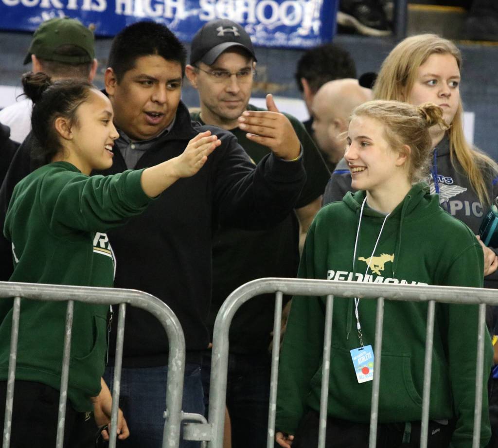 Redmonds Leah Hiatt, left, coach Esteban Herrera, and Molly Williams at state. Andy Nystrom, Reporter