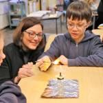 Congresswoman Suzan DelBene watches Stella Schola Middle School students test water absorption, how the paper accepts ink when written on and the effects of fire on the paper. Courtesy of Sara Kuffel, Lake Washington School District