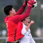 Redmonds Ricardo Escalante makes a save over Snohomishs Eli Esterly in the quarterfinals Friday night at Veterans Memorial Stadiums in Snohomish on May 18. (Kevin Clark / The Herald)