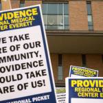 A supporter waves from a window as nurses with UFCW 21 and their supporters picket outside Providence Regional Medical Center Everett on Wednesday. (Andy Bronson / The Herald)