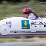 Amelia Allen (left) looks down at the track as she races another driver in unweighted practice soap box derby cars June 7 on Camano Island. The 11th Stanwood-Camano Soap Box Derby takes place Saturday. (Andy Bronson / The Herald)