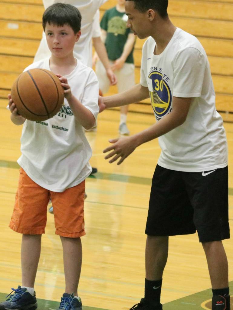 Redmond High player Malakai James, right, shows Ethan Gormley the ropes at last weeks camp. Andy Nystrom / staff photo
