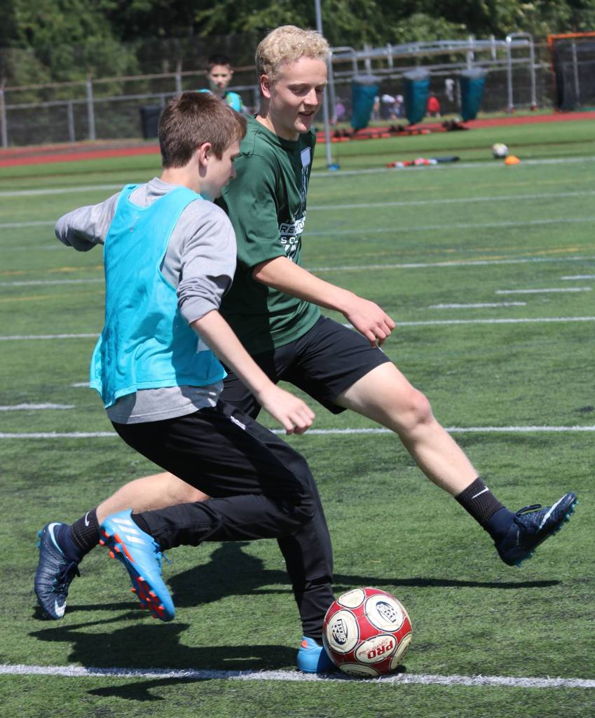 Jonah Cain, left, tries to get the ball past Redmond High player Matthew Michalski. Andy Nystrom / staff photo