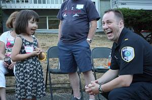 Lieutenant Tim Gately visits with Peyton, a local kid at one of the 65 neighborhood block parties throughout Redmond. Kailan Manandic/Staff Photo