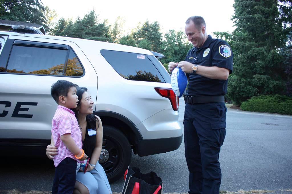 Lieutenant Tim Gately gives small gifts to Aaron Yang at one of the 65 neighborhood block parties throughout Redmond. Kailan Manandic/Staff Photo
