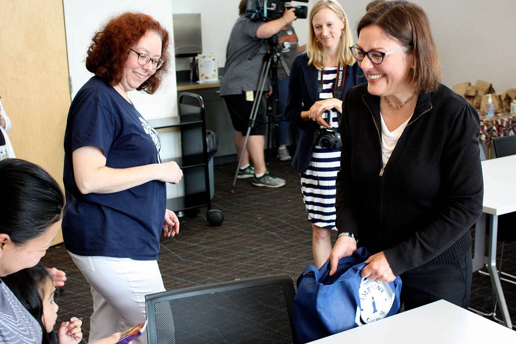 Rep. Suzan DelBene hands out granola bars as a snack for parents who brought their children to the Kingsgate Library Summer Meals program. Kailan Manandic/staff Photo