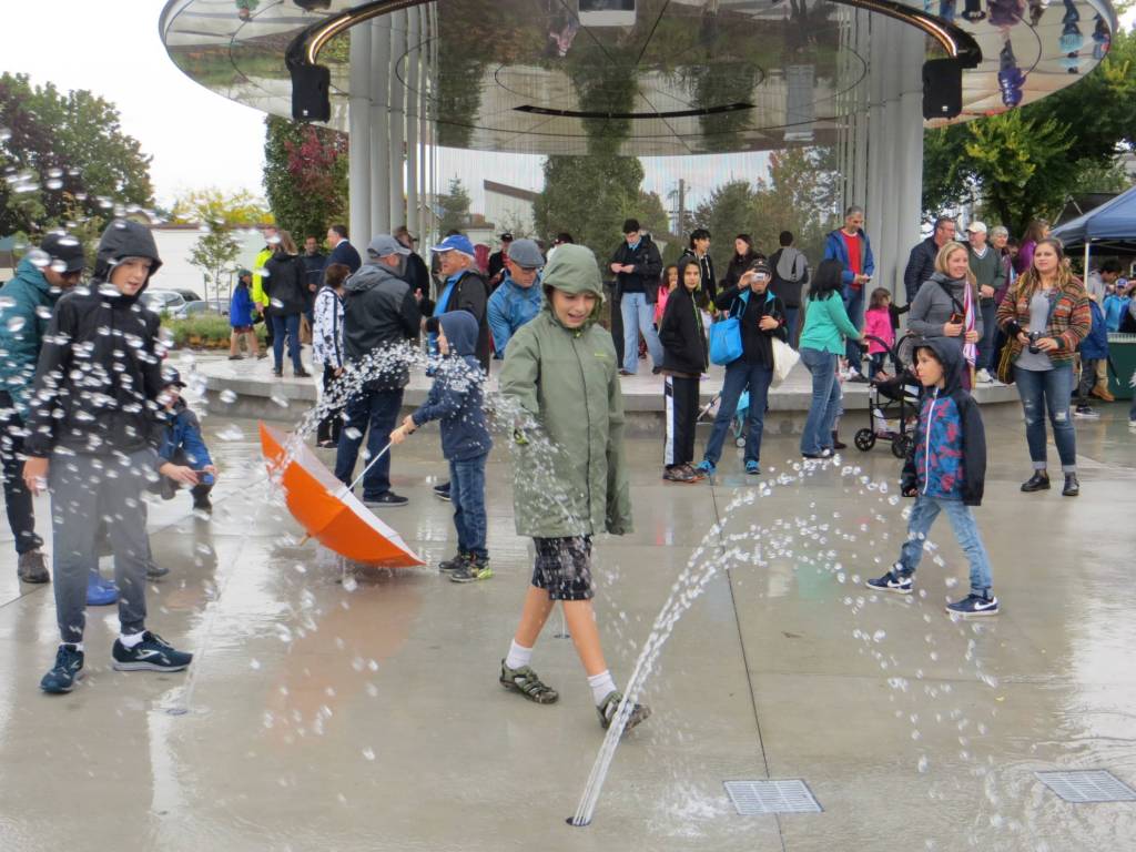 Despite the rain, children still enjoy Downtown Parks splash pad. Samantha Pak/staff photo
