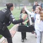 A Redmond police officer high fives Horace Mann Elementary students on International Walk to school Day on Oct. 10. Thousands of schools across the country, including 10 Redmond schools, participated in the 22nd Annual Walk to School Day. Redmond students helped reduce neighborhood traffic congestion and local air pollution by walking, biking, carpooling or riding the school bus. International Walk to School Day is facilitated as a part of Redmonds SchoolPool program. The program works with schools to provide education on safety topics and events like Walk and Bike to School Days to encourage healthy behaviors for students and also rewards local students and schools for reducing the number of drive-alone trips to school. Stephanie Quiroz/staff photo.