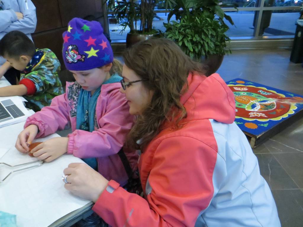 Kristy Hulverson (right) supervises her 5-year-old daughter Caroline as she creates a Diwali lantern with Redmond Balvihaar during Redmond Lights on Dec. 1. Samantha Pak/staff photo