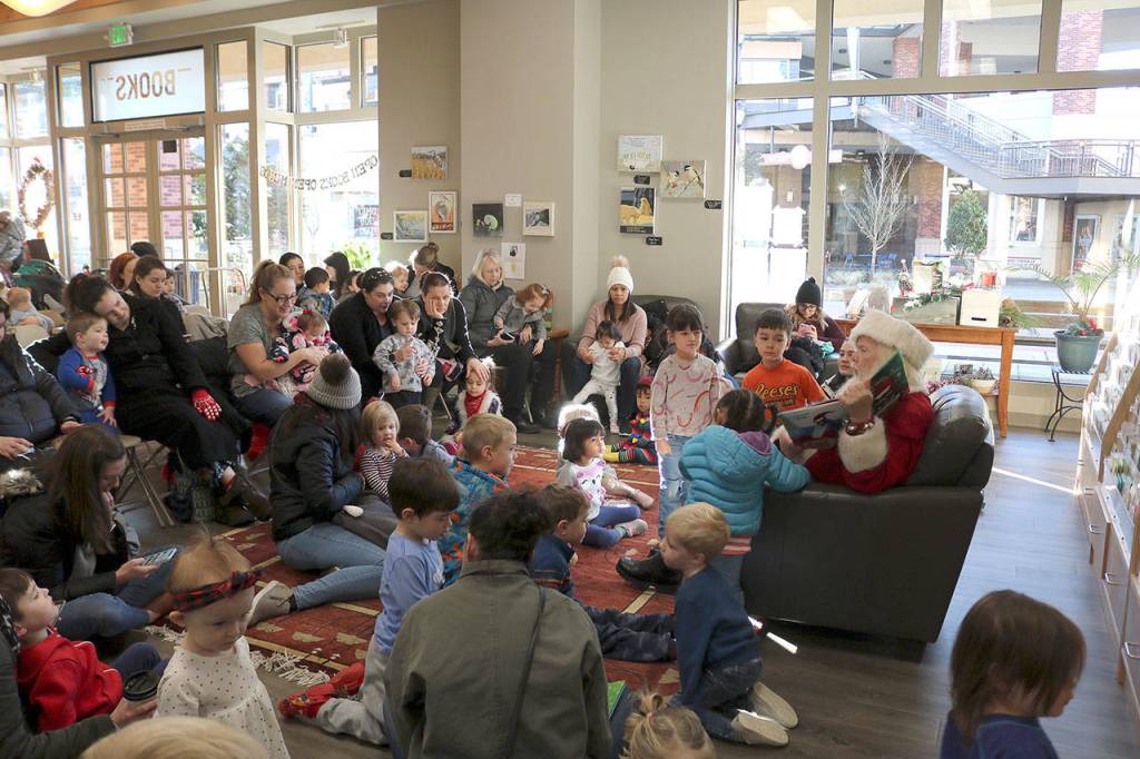 Young children listen to Santa read two Pete The Cat Christmas books. Stephanie Quiroz/staff photo.