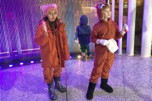 L-R: Lia Mahesh, 8 and Hannah Womble, 8 enjoy singing and dancing on stage during the community holiday sing-a-long. Stephanie Quiroz/staff photo.