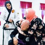 Fauzia Lala watches as one of her students practices self-defense with Bellevue police officer Craig Hanaumi. Photo via Instagram