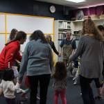 Parents and their children participate in circle time at Joyous Noise.