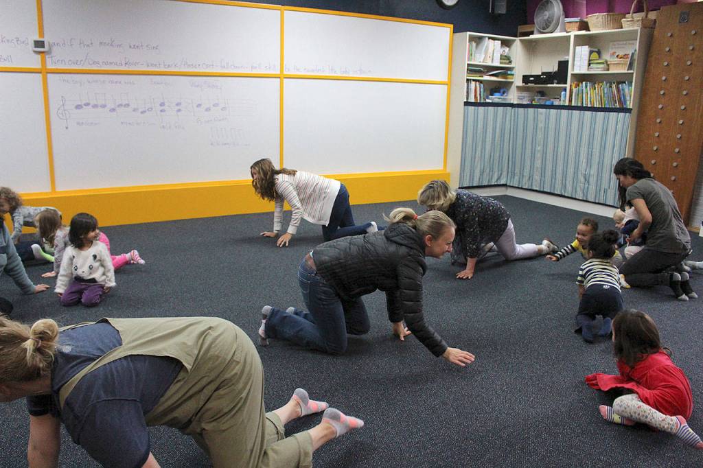 Parents and their children participate in circle time at Joyous Noise.