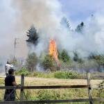 Michael Snook grabbed a water hose to help put out the fires. Photo courtesy of Sue Mitchell
