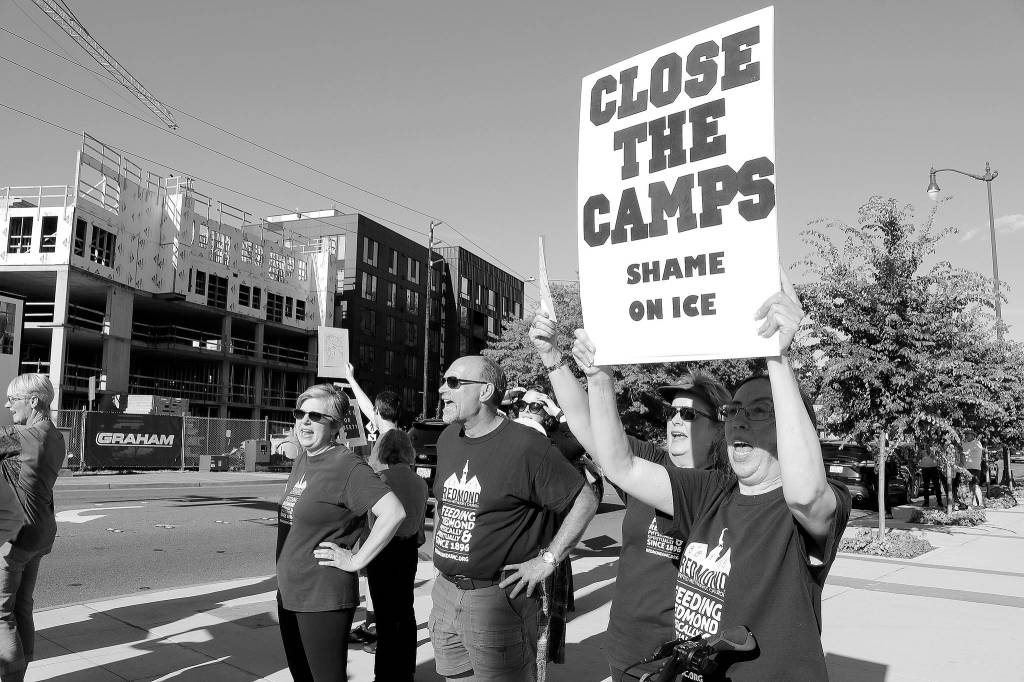 Demonstrators hold their signs at the intersection of Redmond Way and 161st Avenue Northeast, near Downtown Park, on July 12. Stephanie Quiroz/staff photo
