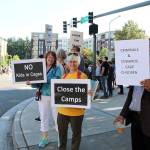 From right, Romi Mahajan, Judy Jesiolowski and Trish Watson hold signs at the intersection of Redmond Way and 161st Avenue Northeast, near Downtown Park, on July 12.