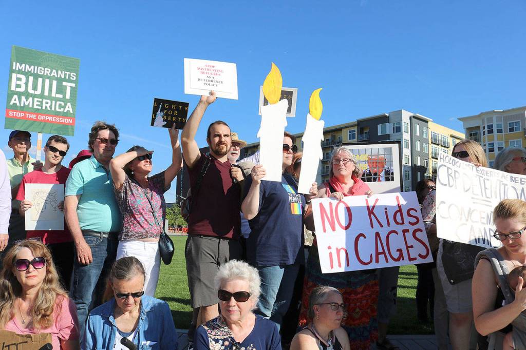 Eastsiders hold their posters on July 12 at the Lights for Liberty Vigil to protest the inhumane conditions faced by migrants. Stephanie Quiroz/staff photo