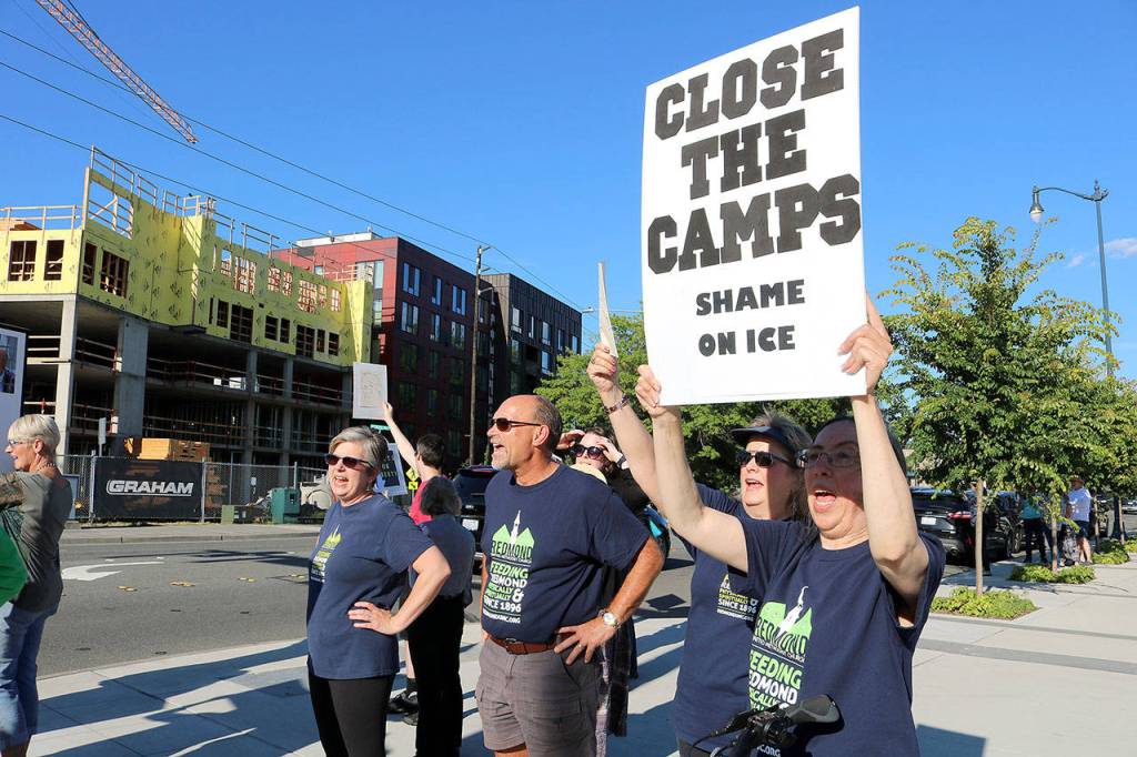 Demonstrators hold their signs at the intersection of Redmond Way and 161st Avenue Northeast, near Downtown Park, on July 12. Stephanie Quiroz/staff photo