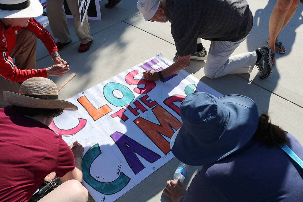 Protestors sign a Close The Camps banner that was delivered to the offices of Sen. Patty Murray (D-WA), Sen. Maria Cantewell (D-WA) and Rep. Suzane DelBene (WA-01). Stephanie Quiroz/staff photo