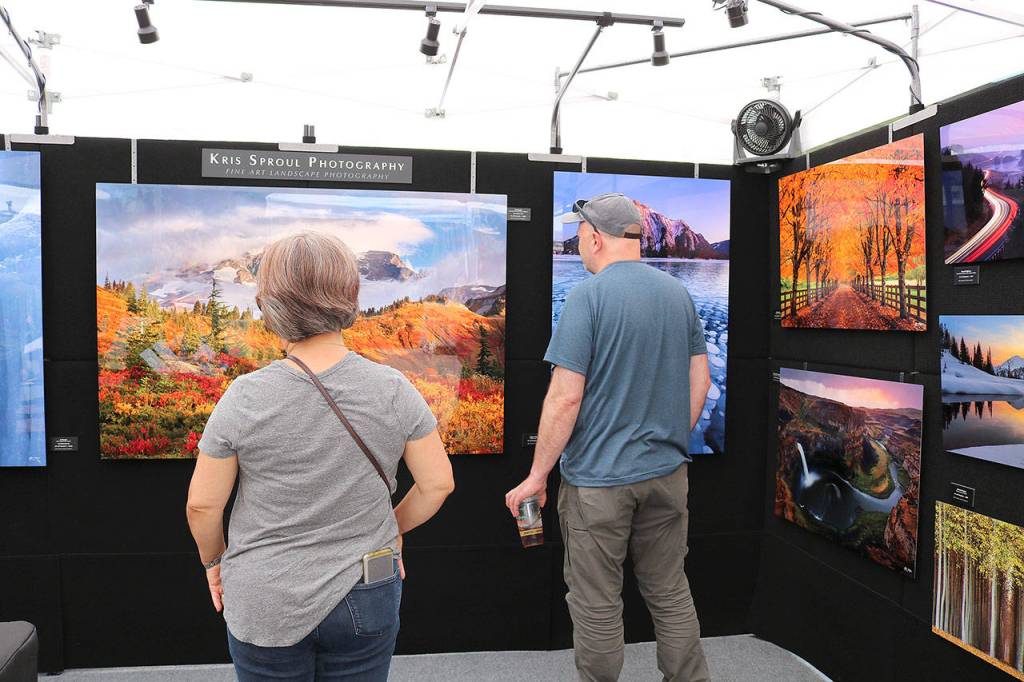 Spectators look at art at the 10th annual Redmond Arts Festival on July 12. Stephanie Quiroz/staff photo