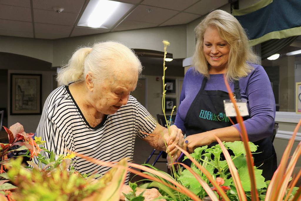 Overlake Terrace resident Nadine Harman helps prune the plants. Stephanie Quiroz/staff photo