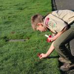 Photo courtesy of Gregory Lucas                                A scout places red poppies, one by one, in the cemetery during a prior event. This years ceremony will happen on Veterans Day, Nov. 11, at Sunset Hills Memorial Park in Bellevue.