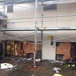 Photo courtesy of the city of Redmond                                 Large scale stucco removal towards the back of the building reveals extensive damage.