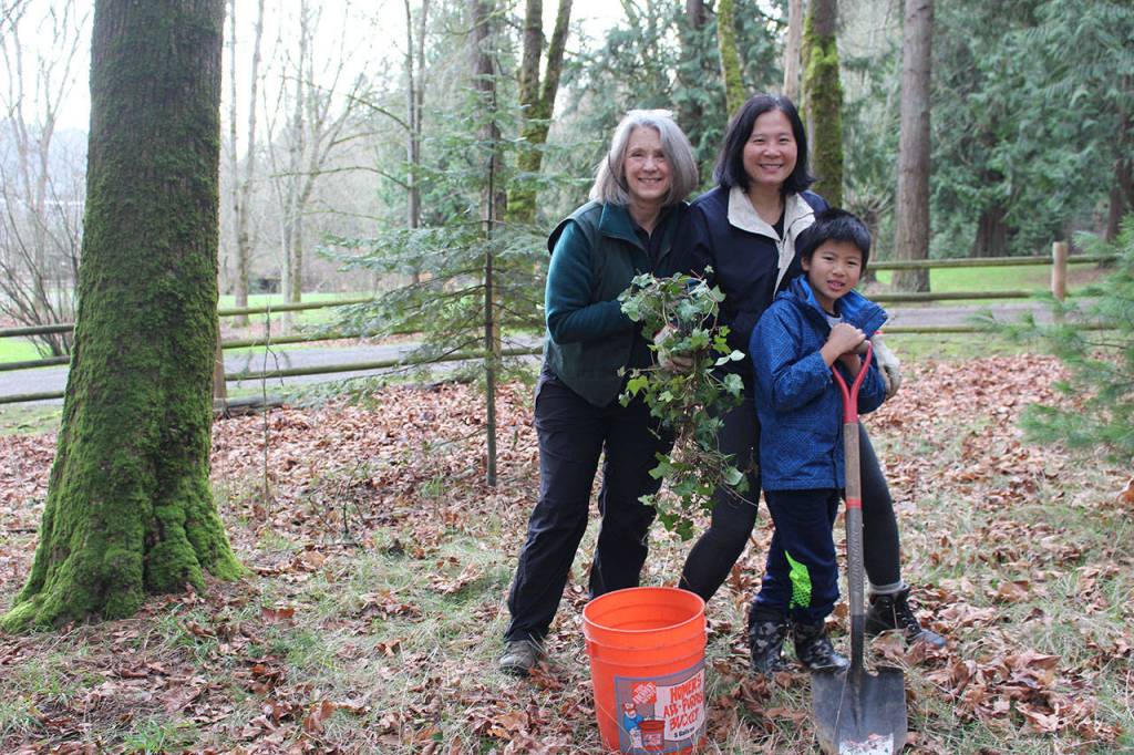 From left, Idylwood Park forest steward Laurie Gogic, Winnie Poon and Joshua Chung take a break in their clean-up work at Idylwood Park. Samantha Pak/staff photo