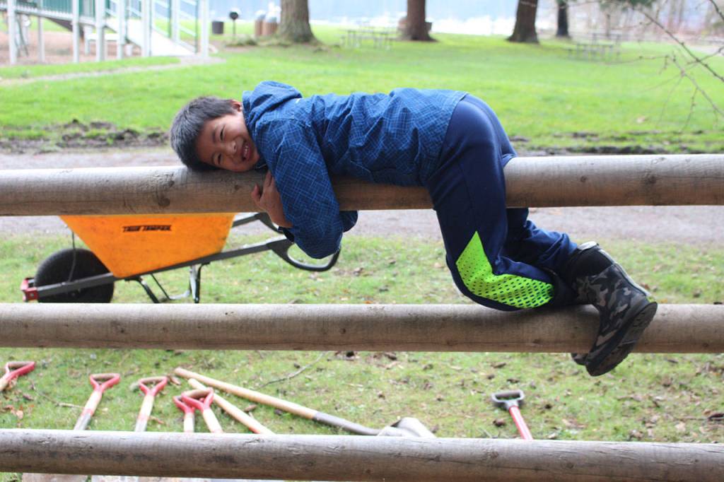 Joshua Chung rests on a fence during a park clean-up event at Idylwood Park in Redmond. Samantha Pak/staff photo