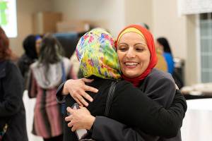 Aneelah Afzali, executive director of MAPS-AMEN and creator of Facts Over Fear campaign, hugs an event attendee before a recent presentation. Photo courtesy of Jeremy Kwong