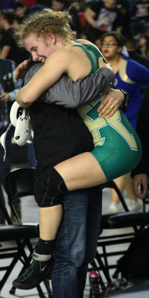 Molly Williams joyfully hugs one of her Redmond High coaches after securing a 12-1 championship win. Andy Nystrom/ staff photo