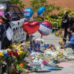 People place flowers at a memorial in front of Bothell City Hall on Tuesday for Officer Jonathan Shoop, who was killed in the line of duty Monday night. (Olivia Vanni / The Herald)