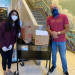 Diya Garg, left, distributes Mighty Crayon recycles crayons and coloring books for Seattle students. Courtesy photo/Diya Garg.