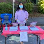 Diya Garg, left, distributes Mighty Crayon recycles crayons and coloring books for Seattle students. Courtesy photo/Diya Garg.