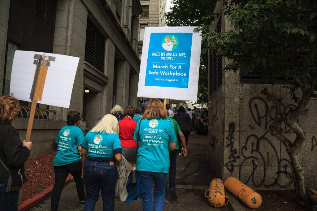 County employees and supporters walk past the King County Courthouse during a march for womens safety at work in Seattle on Friday, Aug. 6, 2021. The march was scheduled after a woman was attacked in a bathroom at the King County Courthouse. Photo by Henry Stewart-Wood/Sound Publishing