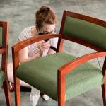 Sarah Berkley repainting a chair at the Furniture Fix-it Fair. Photo courtesy of Xenia Dolovova.
