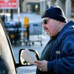 Kevin Flynn, a meat-cutter with the Marysville Albertsons, speaks with a passenger in a vehicle during a leaflet campaign on Wednesday. Flynn was one of about a dozen grocery store workers handing out leaflets to shoppers about the proposed merger between Albertsons and Kroger. (Mike Henneke / The Herald)