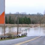 Flood waters flow over NE 124th Street at West Snoqualmie Valley Road NE outside Duvall, Dec. 9, 2025. (Grace Gorenflo/Valley Record)