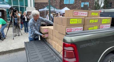A volunteer for Lets Go Washington unloads boxes of petitions for Initiative 645 that were turned in to the Secretary of States office on July 2. The measure to repeal Washingtons new income tax was certified for the November ballot on July 15. (Photo by Jerry Cornfield / Washington State Standard)